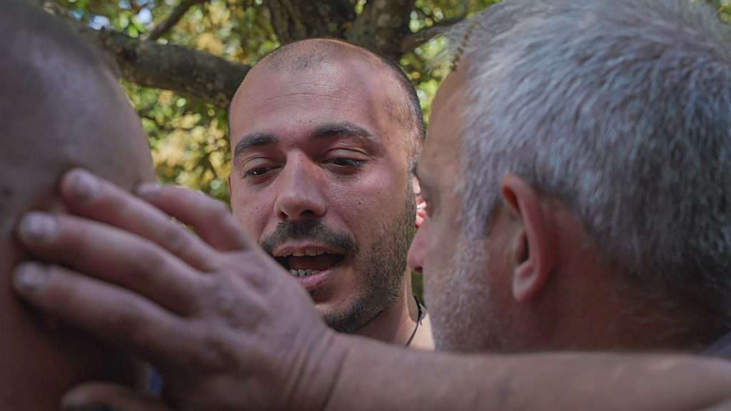 uomini in cerchio eseguono il canto a tenore, un canto tradizionale sardo